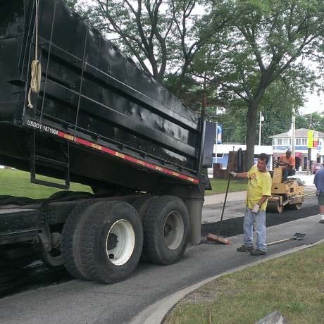 Central Seal coat's employee finishing a cement driveway