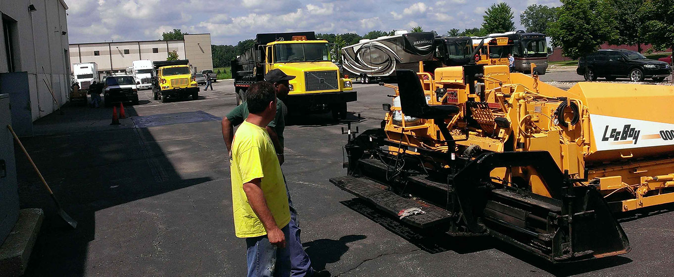 Asphalt and Concrete trucks and Ashpalt spreader and employees 